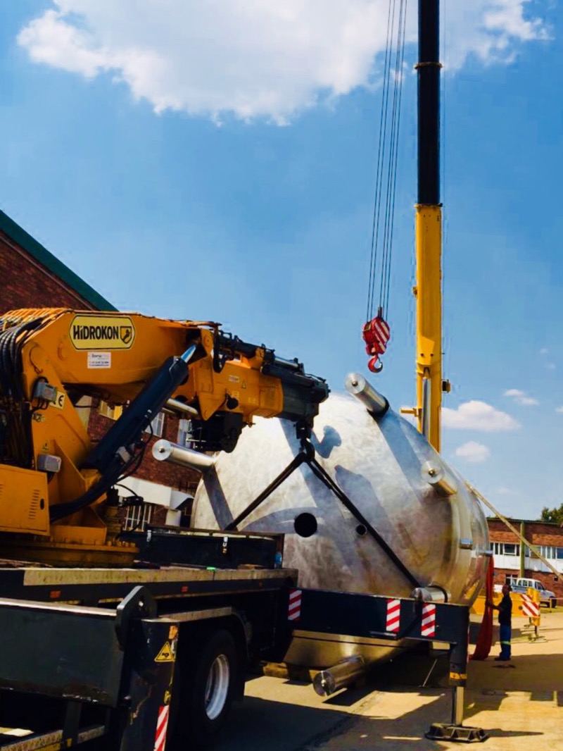 Tandem crane lift placing a stainless steel pressure vessel