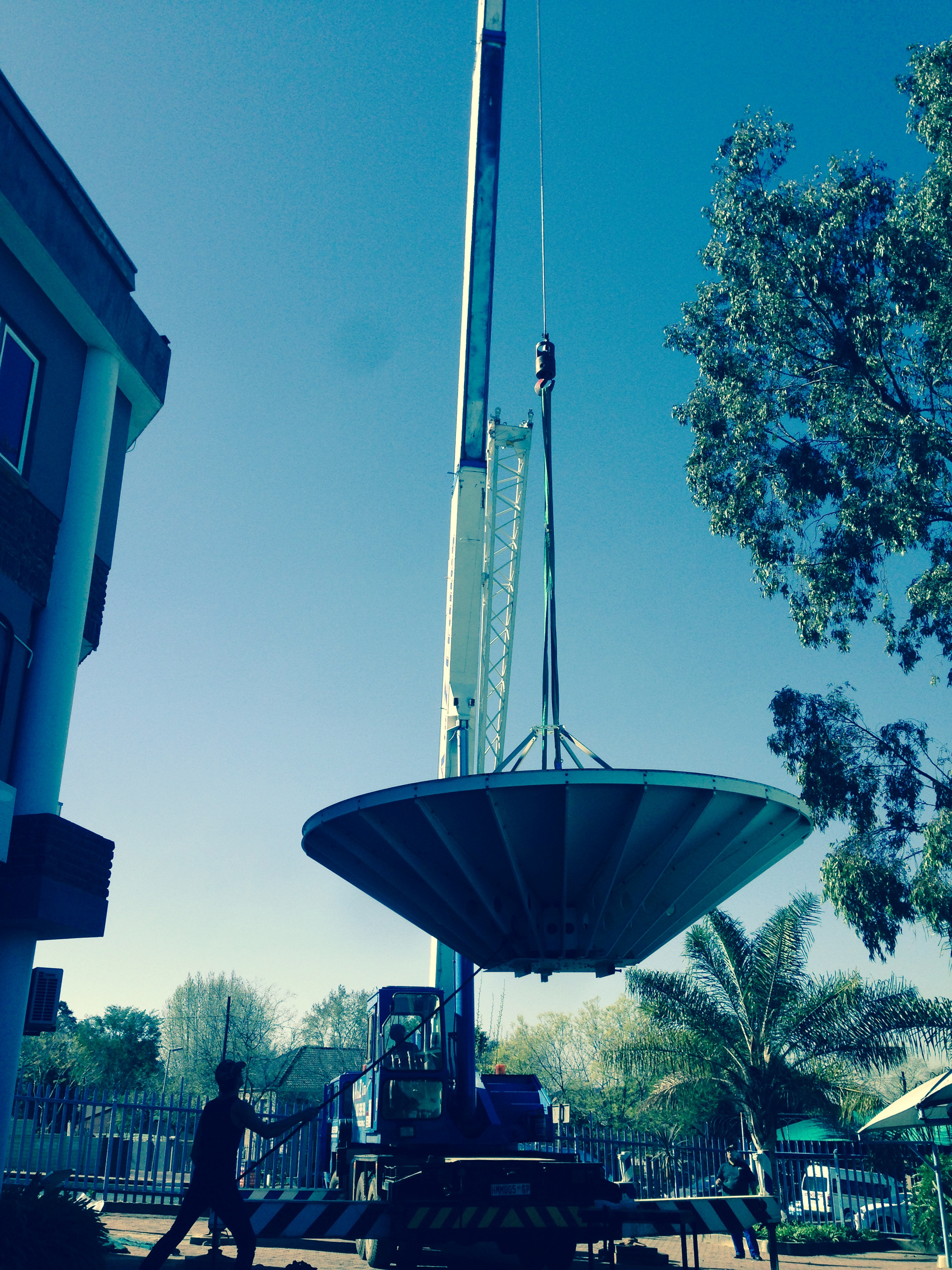 Mobile crane lifting a satellite communications dish