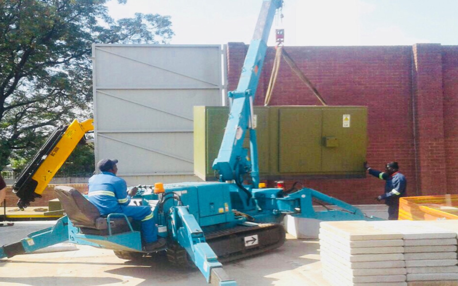 Spider crane positioning a generator in a confined-access industrial setting