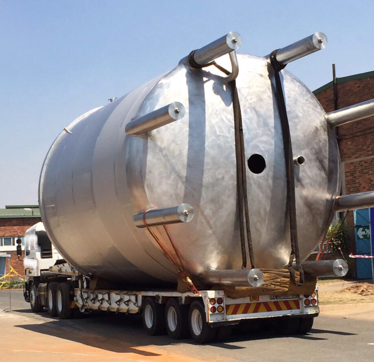 Stainless steel pressure vessel on a multi-axle abnormal-load transport trailer